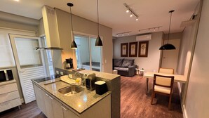 A modern kitchen with a central island, built-in appliances, and pendant lighting.