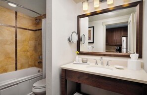 Un bagno moderno con vasca, WC e mobile lavabo con specchio.