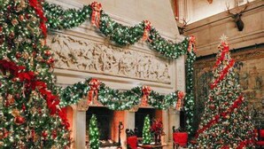 A grand room with a fireplace, Christmas trees, and red chairs. - Large log home in Lake Lure, HOT tub/Game room/pet (Lake Lure)