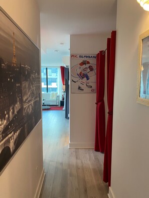 A hallway with a poster of a hockey player, red curtains, and a framed picture on the wall. - CONDO DOWNTOWN MONTREAL - GRIFFINTOWN W (Montréal)