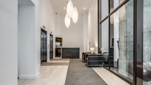 Eine moderne Hotelhalle mit einer Rezeption, einer Sitzecke und einer Glaswand.