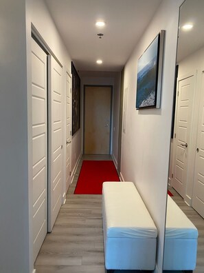 A hallway with a red carpet, white doors, and a painting on the wall. - CONDO DOWNTOWN MONTREAL - GRIFFINTOWN W (Montréal)