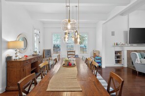 A spacious dining area with a long wooden table, multiple chairs, and a chandelier. - Hot Tub Retreat | Sleeps 12 | 10 mins to Dowtown (Austin)