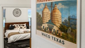 Un quadre amb imatges dels Silos Magnolia a Waco, Texas, penjat sobre una paret blanca.