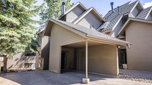 Un edificio a due piani con un portico coperto e un garage.