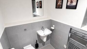 A modern bathroom with a toilet, sink, and towel rack.