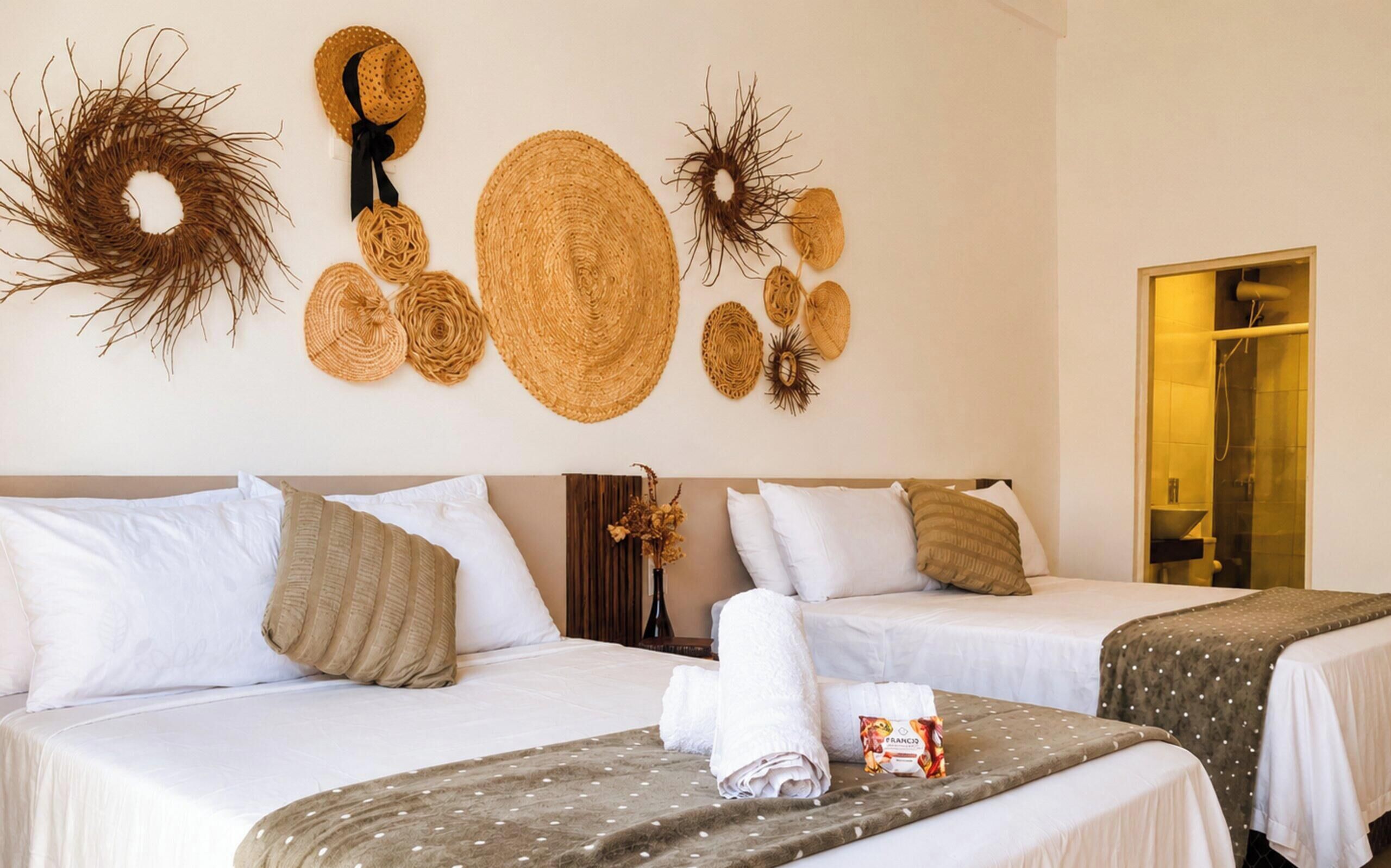 Habitación de hotel con dos camas, zona de ducha y decoración mural.
