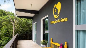 A modern building with a balcony, a logo with a heart and a house, and a sign that reads 'Coração do Rosal'.