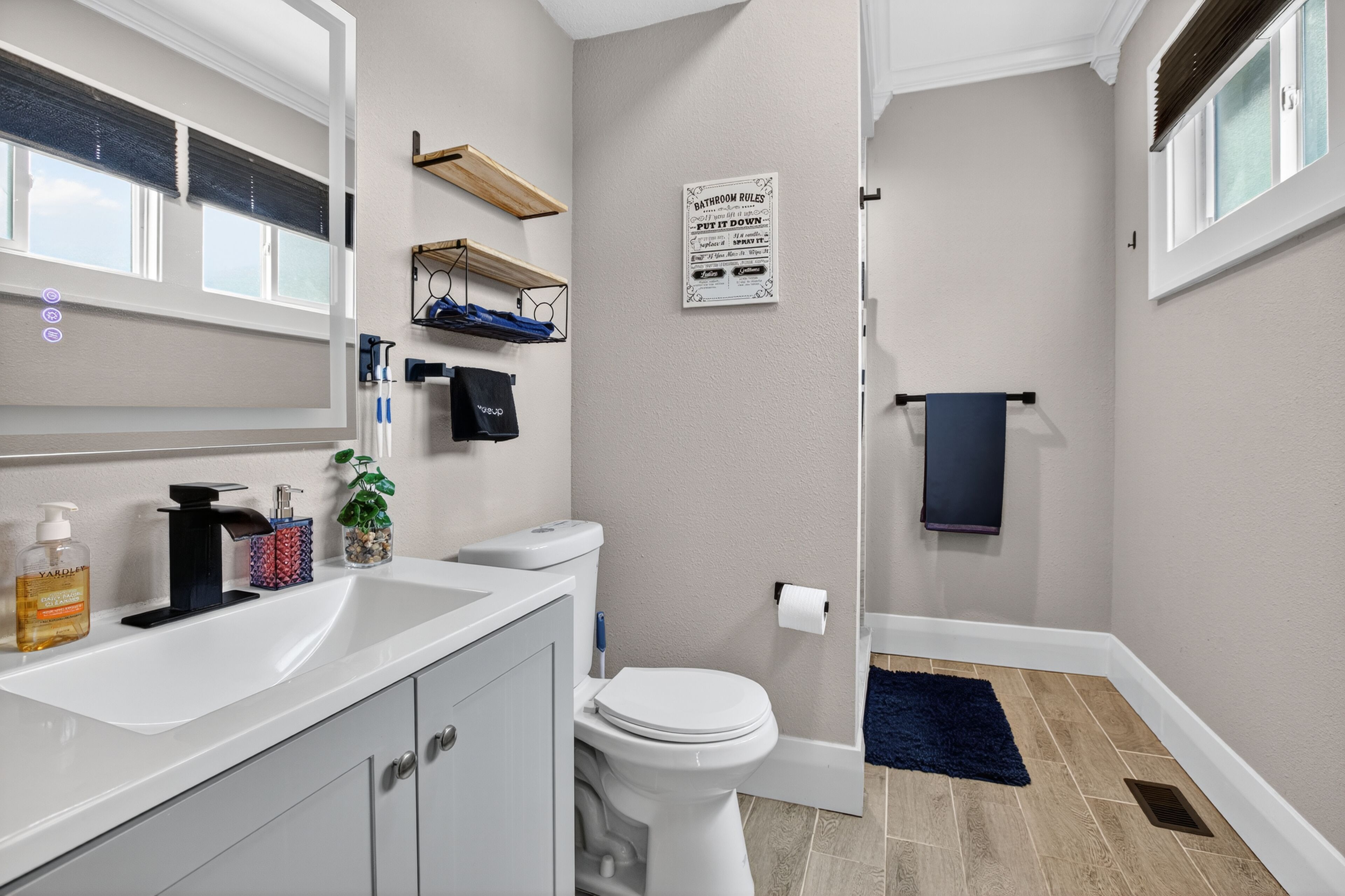 A modern bathroom with a toilet, sink, and shower area.