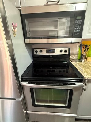 A kitchen with a microwave, oven, and stovetop. - GAVN Ybor Heights (Tampa)