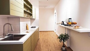 Una cocina moderna con suelo de madera, un lavamanos, armarios y una encimera con una planta.