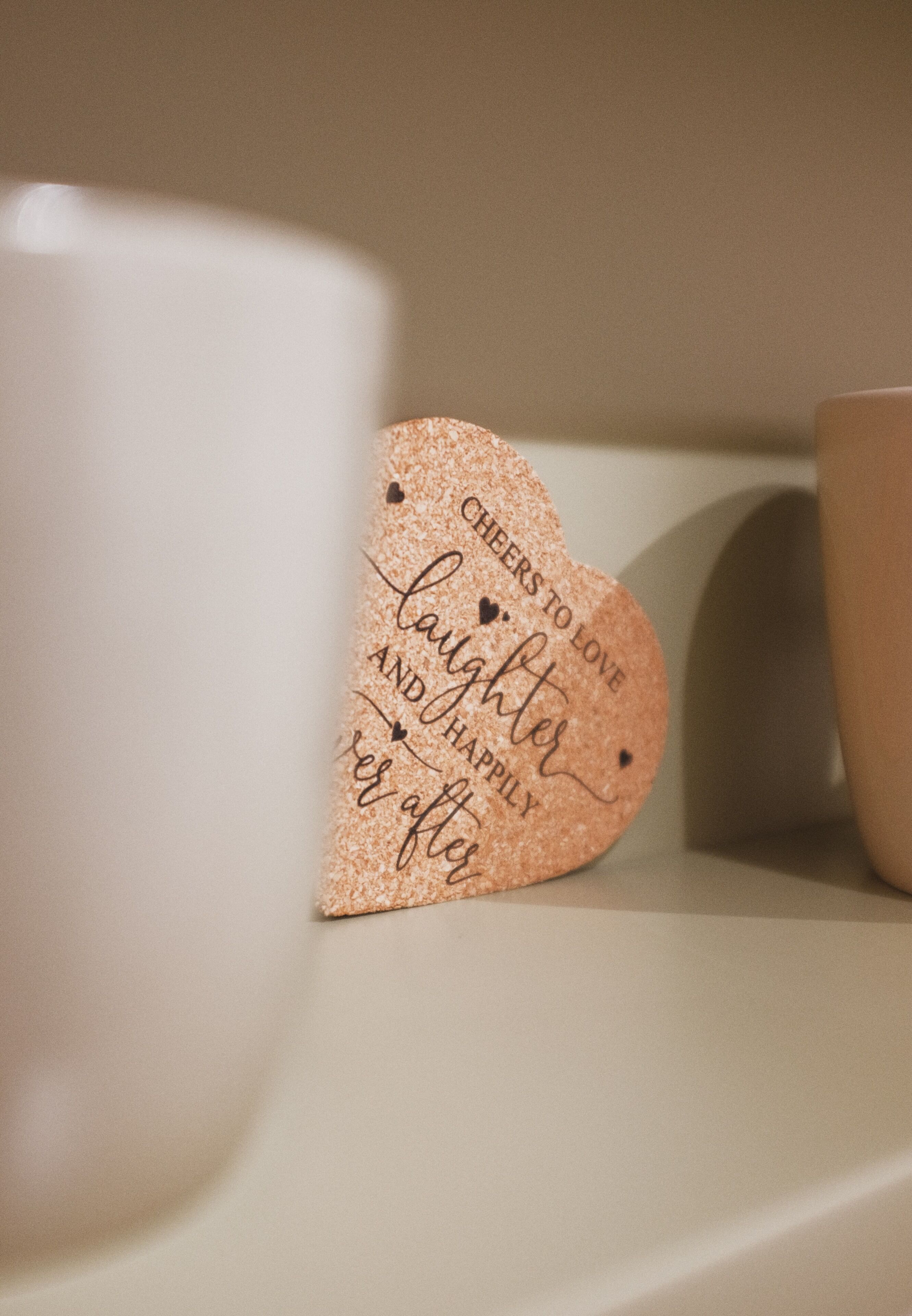 A decorative heart-shaped sign with a message, placed on a shelf.
