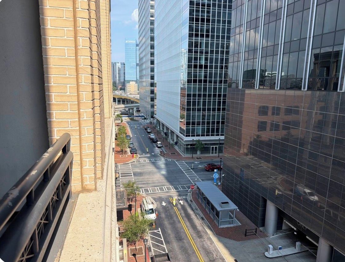 A city street with modern buildings, a tram, and a clear sky.