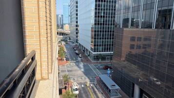 A city street with modern buildings, a tram, and a clear sky.
