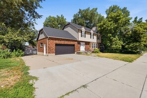 A two-story house with a brick facade and a garage. - Fantastic 2-bedroom apartment with AC in charming East Layton (Layton)