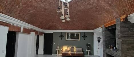 A spacious loft with a high ceiling, a skylight, a fireplace, and a seating area.