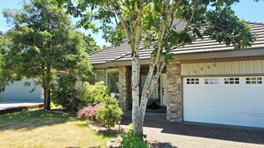 A house with a stone facade, a garage, and a driveway. - Bright & Spacious Estate (Surrey)