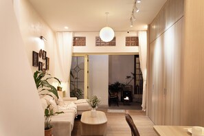 Ein modernes Wohnzimmer mit einer Couch, einem Couchtisch und Topfpflanzen.