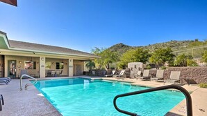 A swimming pool with a clear blue water, surrounded by lounge chairs and a building with a tiled roof. - 2-bedroom condo with Pool, Sauna, Fitness Center and Game room.  (Phoenix)