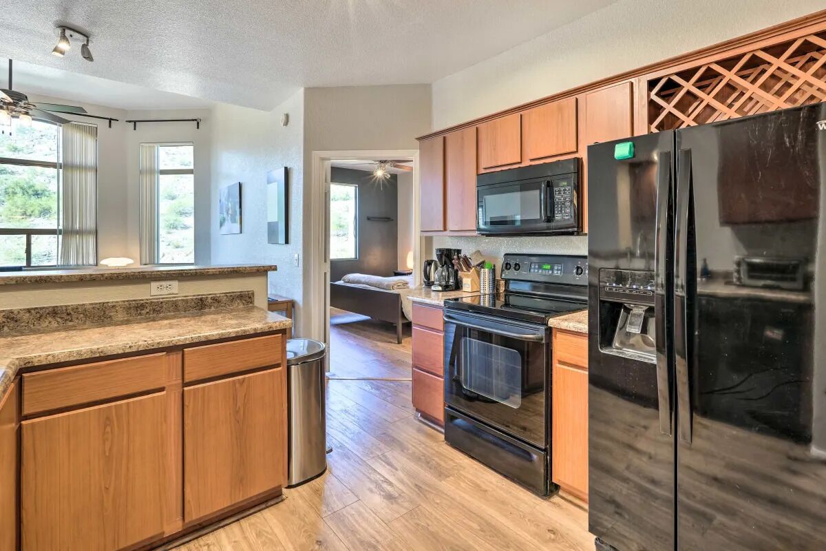 A modern kitchen with wooden cabinets, stainless steel appliances, and a granite countertop.