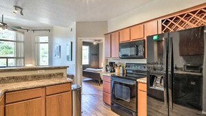 A modern kitchen with wooden cabinets, stainless steel appliances, and a granite countertop. - 2-bedroom condo with Pool, Sauna, Fitness Center and Game room.  (Phoenix)