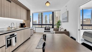 Un appartamento moderno con cucina, zona pranzo e un'ampia finestra vista città.