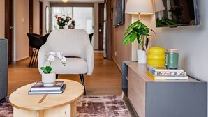 A modern living room with a sofa, a coffee table with books, a lamp, and a plant. - 3 Private Apts in Condesa with Private Terrace (Mexico City)