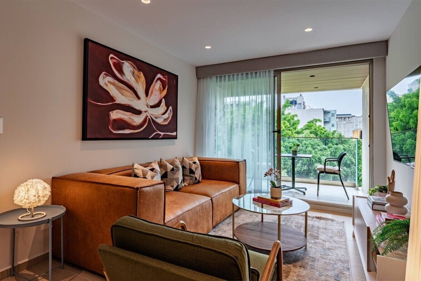 Ein stilvolles Wohnzimmer mit einer Ledersofa, einem Glastisch und einem großen abstrakten Gemälde.