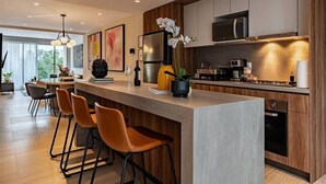 A modern kitchen with a bar area, stainless steel appliances, and a large window. - 3 Private Apts in Condesa with Private Terrace (Mexico City)