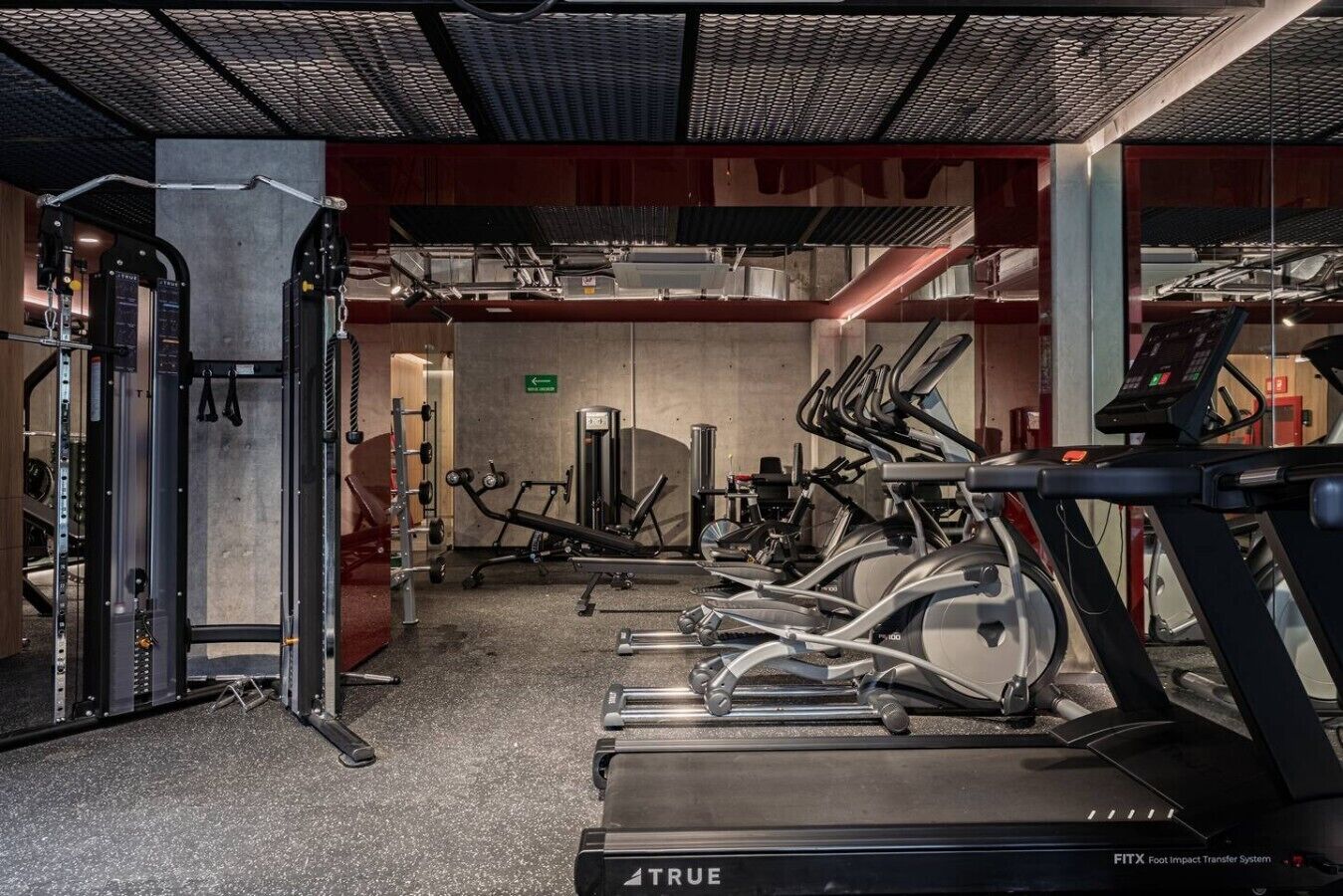A gym with treadmills, weight machines, and a squat rack.