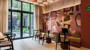Ein modernes Interieur mit einem großen Fenster, einem Sofa, einem Tisch und einem Laptop.