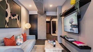 Ein modernes Wohnzimmer mit einer Couch, einem Couchtisch und einem Flachbildfernseher.