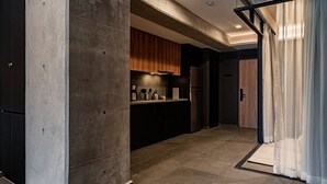 Eine moderne Küche mit einer Betonstütze, Holzschränken und einem Edelstahl-Kühlschrank.