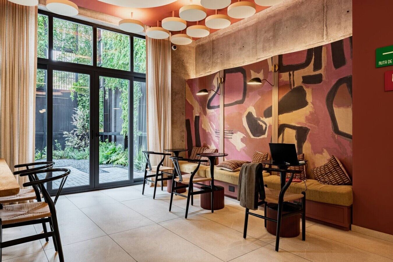 Ein modernes Interieur mit großen Fenstern, einer Couch, einem Tisch und einem Laptop.