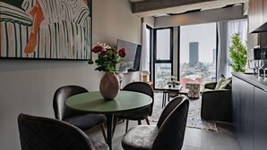 A modern living room with a dining area, a large window with a city view, and a painting on the wall. - Stylish Stay Across from Monumento a la Revolución (Mexico City)