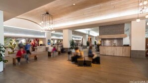 Eine geräumige Lobby mit Holzboden, einer Rezeption und Sitzbereichen.
