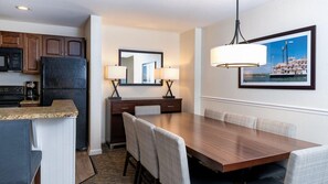 Une chambre d’hôtel dotée d’une cuisine, d’un coin repas et d’une grande fenêtre offrant une vue dégagée.