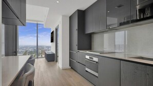 A modern kitchen with a large window, a dining area with a high table, and a city view. - E4010A - Modern 1BR with Balcony & West View in Downtown Miami (Miami Beach)