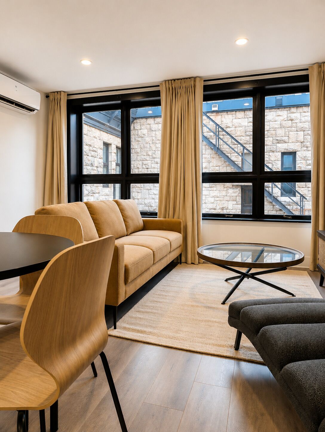 Uma sala de estar moderna com sofá, mesa de centro redonda e mesa de jantar com cadeiras.