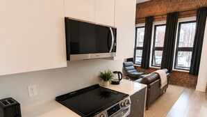 Cocina moderna con microondas, estufa y tostadora integrados.