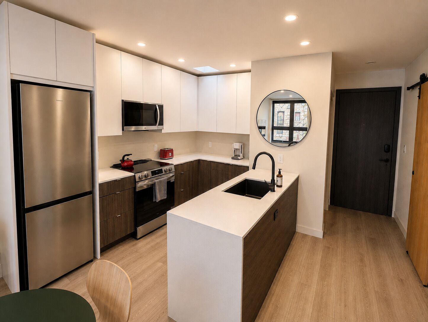 Una cocina moderna con refrigerador, estufa, microondas y pileta.