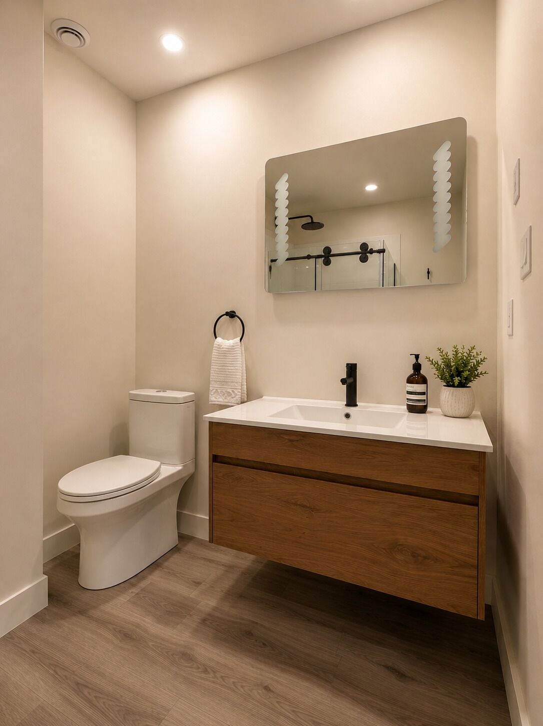 Une salle de bain moderne avec des toilettes, un lavabo et un miroir.