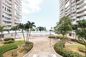 A hotel with multiple floors, a central courtyard with a pool, and surrounding greenery. - Oceanfront Family Retreat 2BR2BA Penthouse Pool & Parking (Carolina)