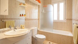 Ein Badezimmer mit Waschbecken, Toilette und Badewanne.
