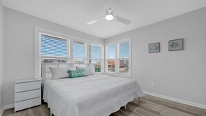 A bedroom with a bed, nightstands, a ceiling fan, and large windows with blinds. - Twin Palms - Unit 1 - 2 Bedroom • 2 Bath - Private Pool - 150 Feet to the Beach (Gulf Shores)