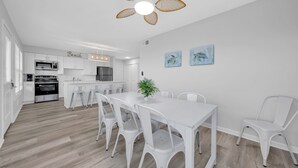 A modern kitchen with white cabinetry, a central island, and a ceiling fan. - Twin Palms - Unit 1 - 2 Bedroom • 2 Bath - Private Pool - 150 Feet to the Beach (Gulf Shores)