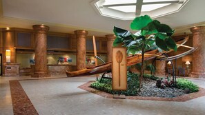 A lobby with a reception desk, large columns, a central plant display, and a seating area. - Cozy Island Retreat at Marriott's Kaua'i Beach Club (Lihue)