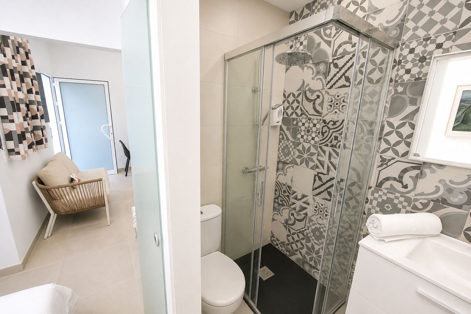 Un baño con cabina de ducha de vidrio, inodoro y lavabo.