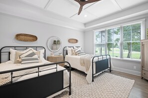 A bedroom with two beds, a ceiling fan, large windows, and a herringbone-patterned floor. - McLemore Resort - 18 Hawthorne Lane - Golf Course View (Rising Fawn)