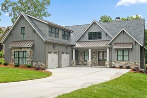 A two-story house with a stone facade, a garage, and a front porch. - McLemore Resort - 18 Hawthorne Lane - Golf Course View (Rising Fawn)